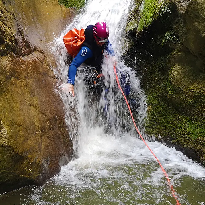 Sliding along waterfall in canyoning Ganière, Gorges du Loup, french riviera - Les Geckos