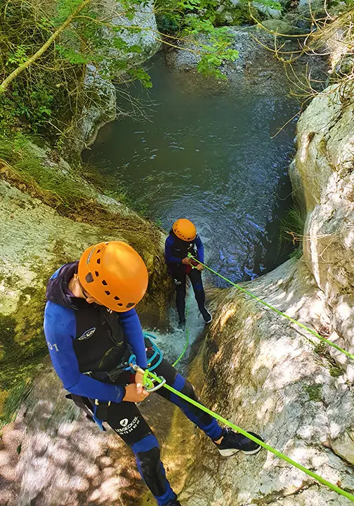 Abseiling down and sliding along waterfall in canyoning Ganière, Gorges du Loup, french riviera - Les Geckos
