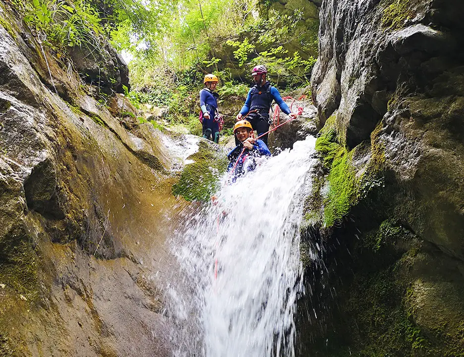 Abseiling down and sliding along waterfall in canyoning Ganière, Gorges du Loup, french riviera - Les Geckos