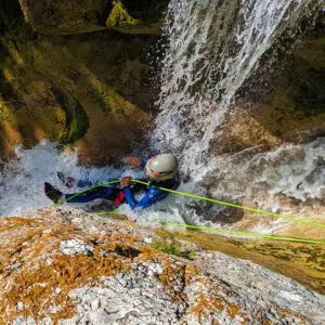 Abseiling down and sliding along waterfall in canyoning Gours du Ray, Gréolières, Gorges du Loup, french riviera - Les Geckos
